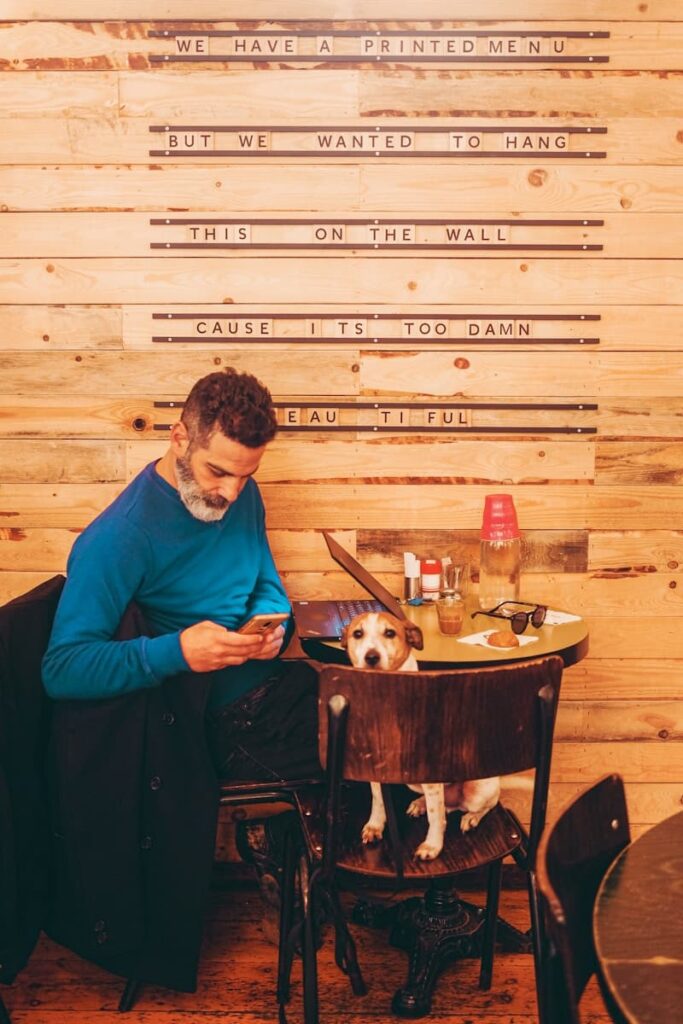 man in blue long sleeve shirt sitting on brown wooden seat