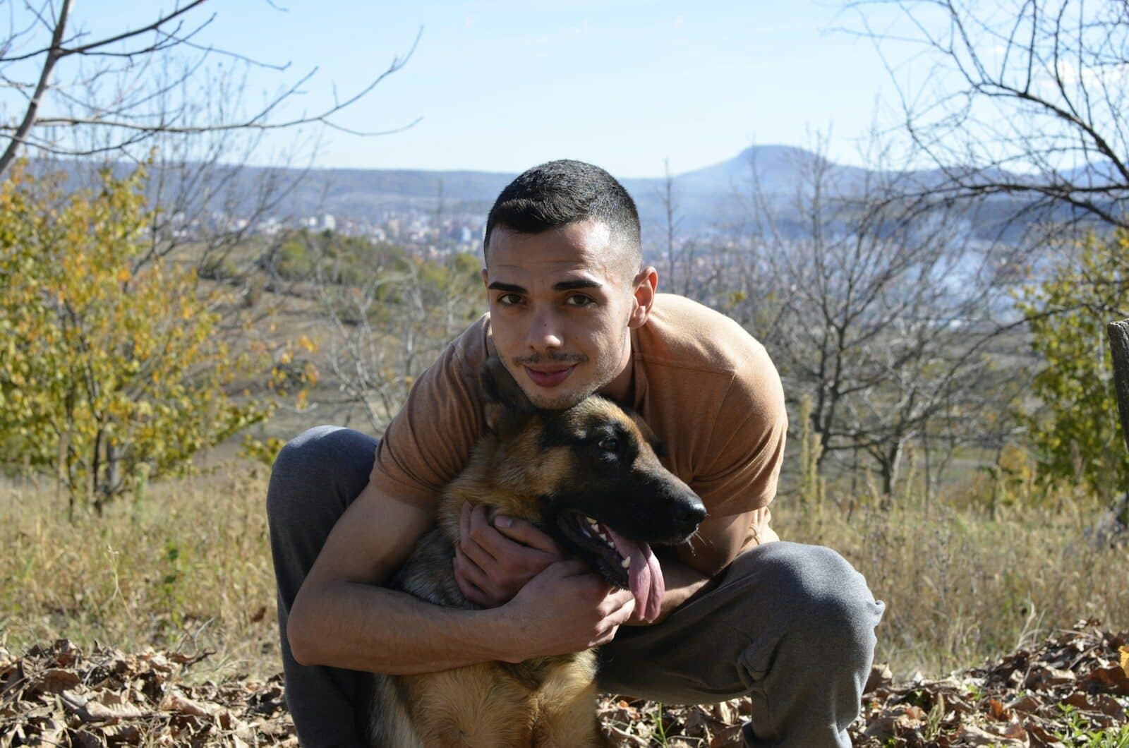 a man is holding a dog in a field